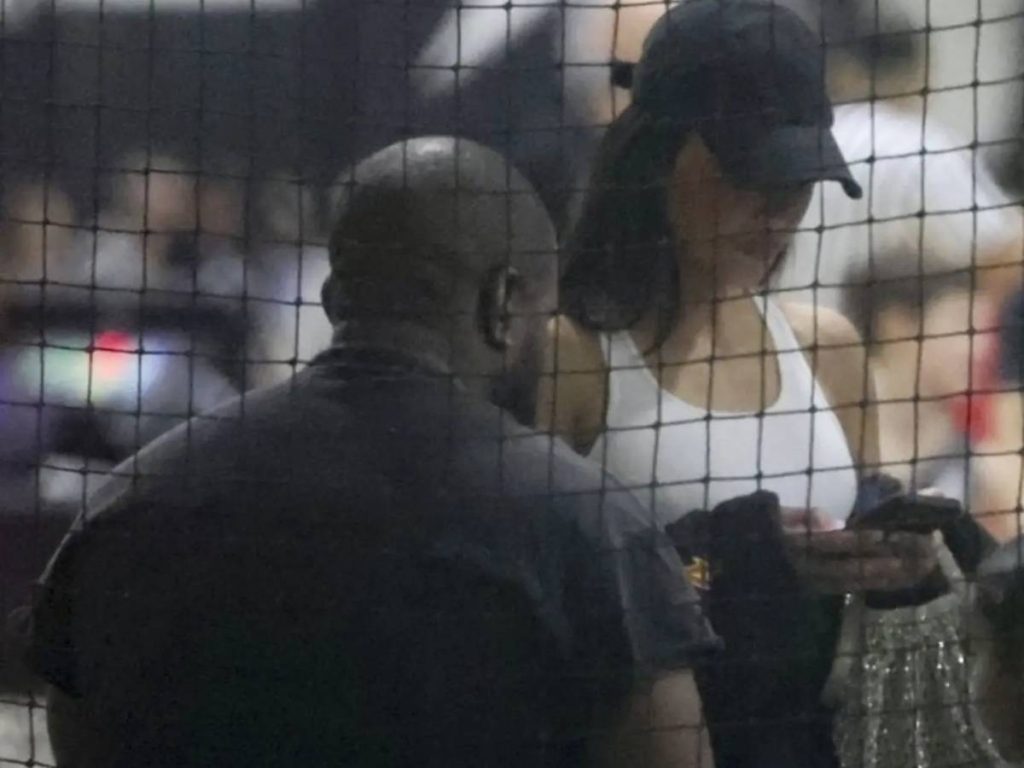 Kim texting at At Saint's Basketball game
